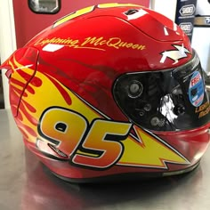 a red helmet with yellow flames on it sitting on top of a table next to a door