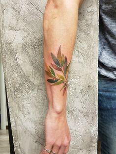 a person with a leaf tattoo on their arm