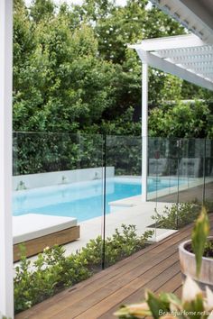 a wooden deck next to a swimming pool