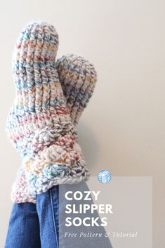 a person wearing a knitted mitten with the words cozy slipper socks on it