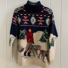 an ugly sweater hanging on a wall with a horse drawn sleigh in the snow