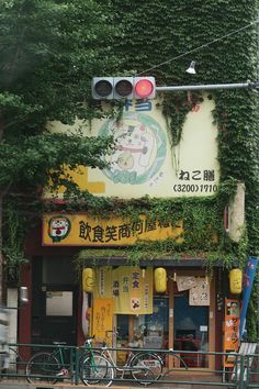 a building with vines growing on the side of it and bicycles parked in front of it