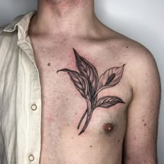 a man with a leaf tattoo on his chest