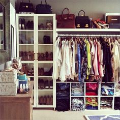 the closet is full of clothes and bags