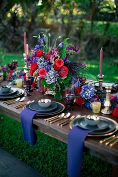 the table is set with purple and red flowers