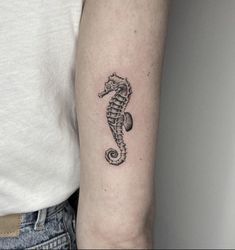 a small seahorse tattoo on the left arm