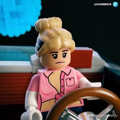 there is a lego woman sitting at the steering wheel