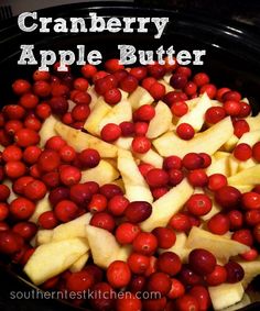 cranberry apple butter is in a crock pot with apples and cherries