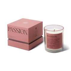 a pink candle sitting next to a box on top of a white surface with the word passion written in it