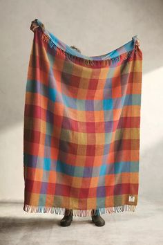 a person standing in front of a plaid blanket