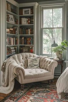 a couch sitting in front of a window next to a bed