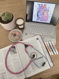 an open book with a stethoscope on top of it next to a laptop