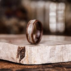 two wedding rings sitting on top of a piece of wood that has been carved into it