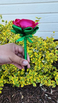 a person is holding a fake rose in their hand