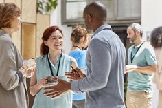 a group of people standing around talking to each other