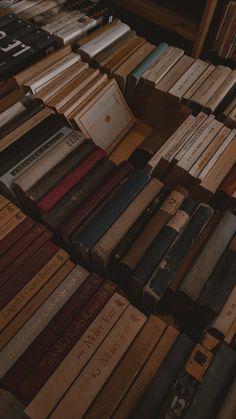 many old books are stacked on top of each other in rows, and one is empty