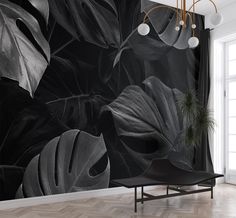 a black and white wall mural with large leaves