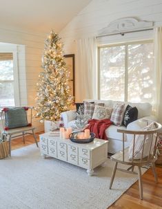 a living room filled with furniture and a christmas tree