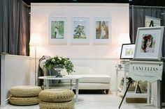 a living room with white furniture and pictures on the wall above it's coffee table