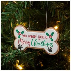 a dog bone ornament hanging from a christmas tree with the words, we wish you a merry christmas