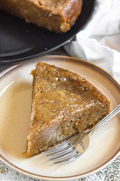 a piece of pie on a plate with a fork next to it and another slice in the background