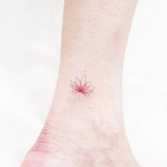 a small flower tattoo on the ankle is shown in red ink, and it appears to be pink