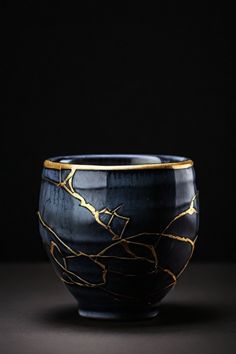 a black and gold bowl sitting on top of a table