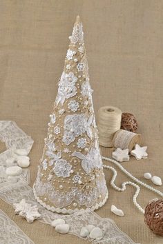 a white christmas tree sitting on top of a table next to twine spools