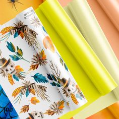 an assortment of colorful wrapping paper on top of each other with skulls and leaves printed on them