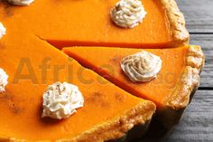 a pumpkin pie with whipped cream toppings on it's crust, ready to be eaten