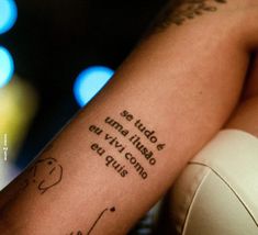 a woman with a tattoo on her arm that reads, so tutto una tiraso en vive conjo