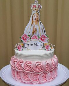 a cake decorated with pink roses and an image of the virgin mary