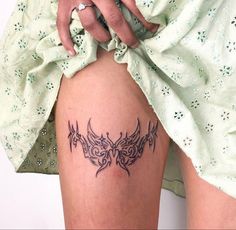 a woman with a tattoo on her thigh