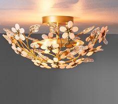 a ceiling light with flowers on it in a living room or dining room, that is lit up