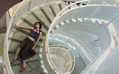 a woman standing on top of a spiral staircase