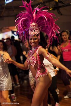 a woman in a pink costume dancing on a dance floor with other people around her