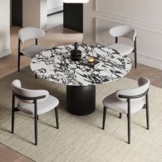 a marble dining table with four chairs around it