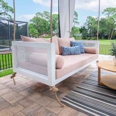 a white swing bed sitting on top of a patio