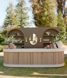 an outdoor bar with mirrors and vases on it