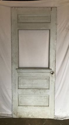 an old white door in front of a white wall