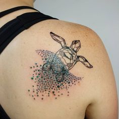 a woman's back shoulder with a tattoo of a turtle and bubbles on it