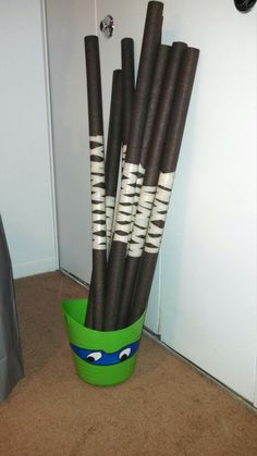 a green bucket filled with black and white sticks