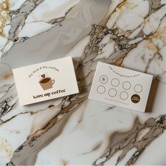 two business cards sitting next to each other on a marble counter top with gold foil