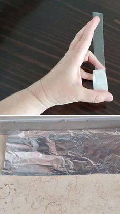 a person holding something in their hand near a piece of tin foil on a table