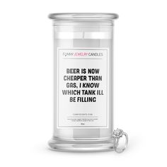 a white candle with a quote on it and a silver ball in front of it