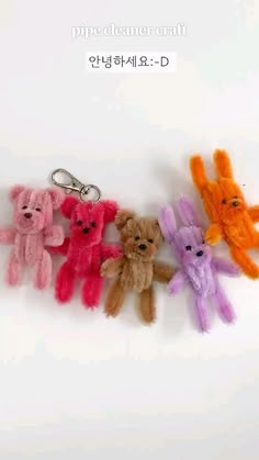 four small stuffed animals are hanging from a key chain