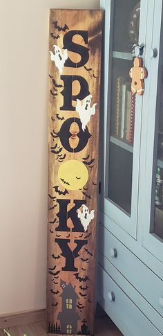 a wooden sign sitting on top of a hard wood floor next to a book shelf