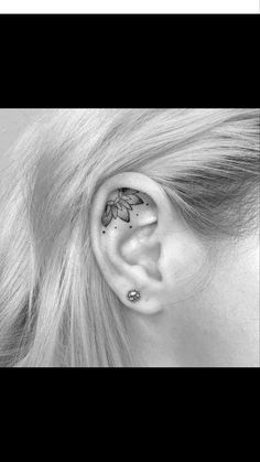 black and white photo of a woman's ear with flowers on it, in the middle