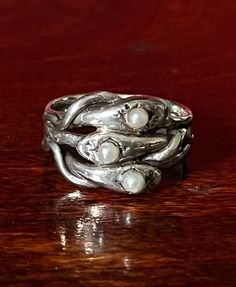 Three intertwined snakes, each with a single faux pearl, make up the face of this ring which is approximately 1/2" long. This ring is marked Sterling and is a size 7. Aside from some wear to the stones, it is in very good preloved condition. Please see all photos for details and condition. Thank you for looking! Handmade Silver Symbolic Snake Ring, Handmade Symbolic Sterling Silver Snake Ring, Sterling Silver Symbolic Snake Ring Collectible, Handmade Vintage Silver Snake Ring, Vintage Sterling Silver Snake Ring Gift, Vintage Silver Jewelry, Snake Ring, Pretty Jewellery, Vintage Sterling Silver