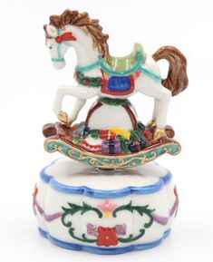 a figurine of a carousel horse on top of a white base with multicolored decorations